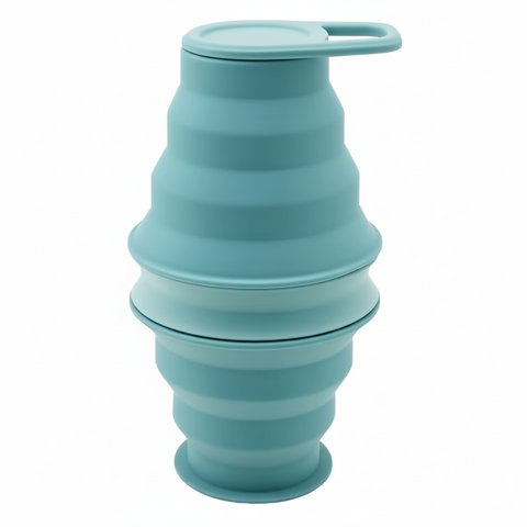 Mint collapsible silicone water bottle collapsed down short and secured with its carry-loop cap, on pure white background